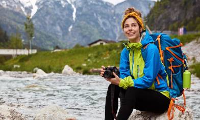 a person sitting on a rock in the mountains