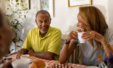 a group of over 60s smiling and drinking a hot beverage
