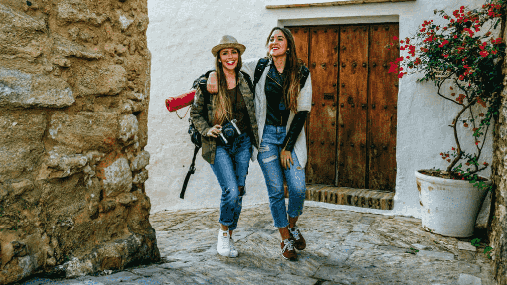 two people meandering along an old walled city street